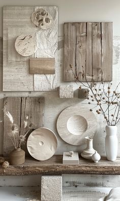 an assortment of white dishes and vases are displayed on a shelf in a room