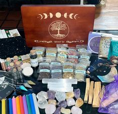 an assortment of crafting supplies on a table with a wooden box in the background