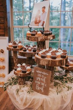 cupcakes are arranged on top of the cake stand at this rustic wedding reception