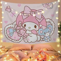 a hello kitty wall hanging over a bed in a room with lights on the floor