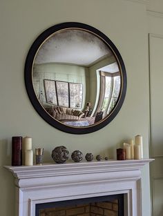 a fire place with a mirror on the wall above it