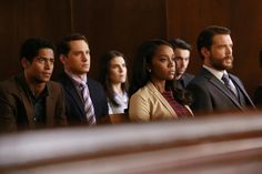 a group of people sitting next to each other in front of a wooden paneled wall