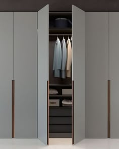 an open closet with clothes hanging in it