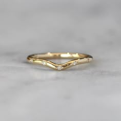 a gold wedding band with three small diamonds on the top, and one diamond in the middle