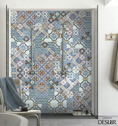 a bathroom with blue and white tiles on the shower wall next to a bath tub