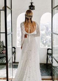 a woman in a white wedding dress looking out the window