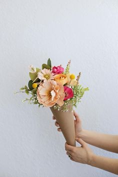 someone holding a bouquet of flowers in their hand