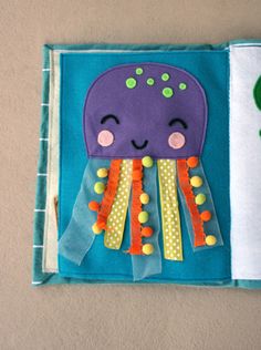 an octopus book is open to show the pages and it's cover with buttons