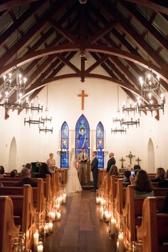 a bride and groom standing at the alter in front of candles during their wedding ceremony