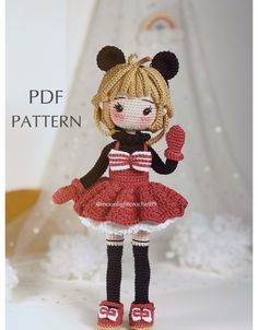 a crocheted doll wearing a red and white dress with black ears, holding a mitten