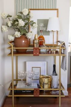 a gold bar cart with drinks and flowers on top