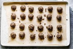 raw balls of food on a baking sheet ready to be baked in the oven for consumption