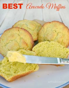 a white plate topped with muffins next to a knife