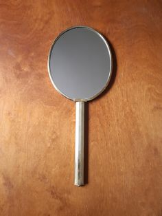 a mirror sitting on top of a wooden table