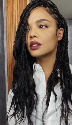 a woman with long black hair wearing a white shirt and red lipstick on her lips