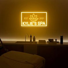 a yellow sign that says kyllie's spa in front of a sink and counter