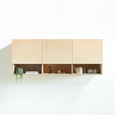 a wooden shelf with pots and cups on it next to a wall mounted planter