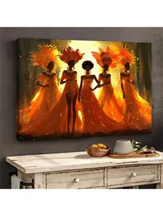 three women in orange dresses are standing on a table with an orange painting behind them