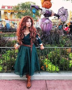 a woman dressed up as merida from brave and the world of gump, standing in front of some pumpkins