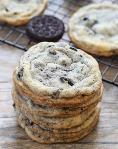 chocolate chip cookies stacked on top of each other next to a cooling rack with oreos