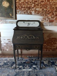 an old black piano sitting on top of a blue rug in front of a brick wall