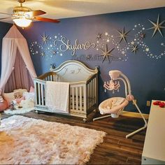 a baby's room decorated in blue and white with stars on the wall above it