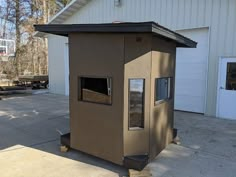 an outhouse is shown in front of a building with a basketball hoop behind it