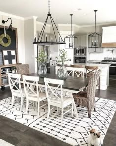 a dining room table with chairs and a dog sitting on the floor in front of it