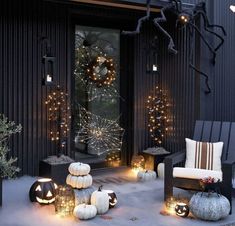 a porch decorated for halloween with pumpkins and lights