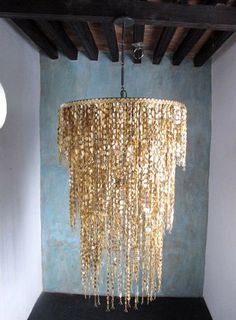 a chandelier hanging from the ceiling in a room with blue walls and wooden beams