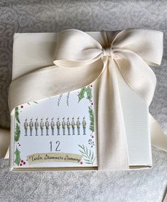 a gift wrapped in white paper with a ribbon around it and the number twelve on it