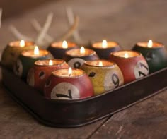 candles are lined up in the shape of billiard's pool balls with numbers painted on them