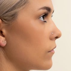 a woman with ear piercings on her nose