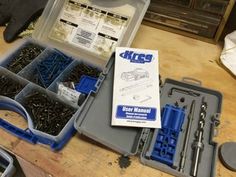 there are many screws in the case on the table with other tools and accessories