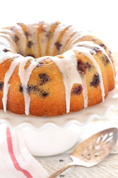 a blueberry bunt cake with icing on a white plate