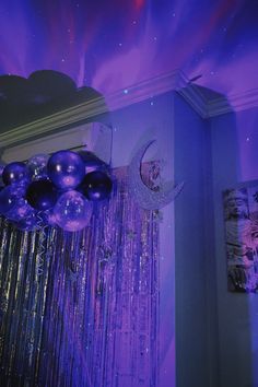 balloons and streamers are hanging from the ceiling in front of a purple background with stars