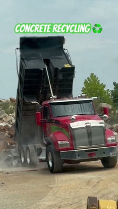 a dump truck driving down a dirt road