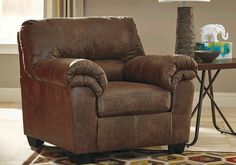 a living room with a brown recliner and a rug in front of the couch