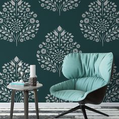 a chair and table in front of a green wall with white flowers on the wall