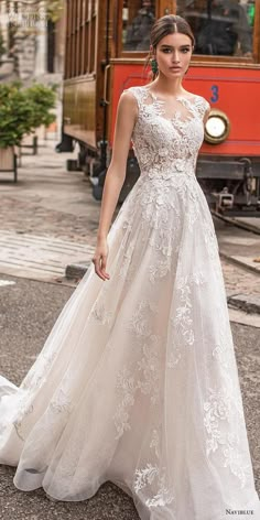 a woman in a wedding dress is standing on the street with a trolley behind her