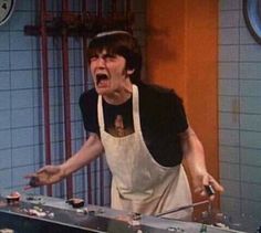 a man in an apron is screaming at something