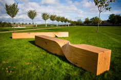 two wooden benches sitting on top of a lush green field