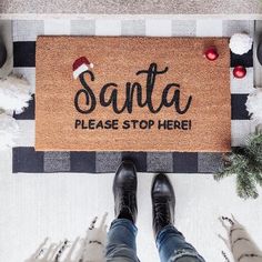 someone standing in front of a door mat that says santa please stop here