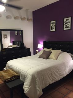 a bedroom with purple walls and white bedding