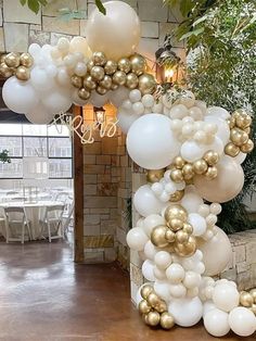 white and gold balloons are hanging from the ceiling