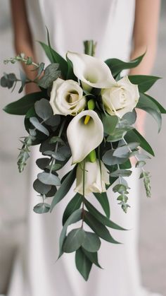 a bridal bouquet with white flowers and greenery