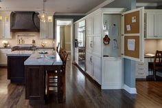 a large kitchen with white cabinets and wood floors