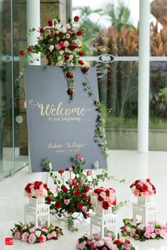 the welcome sign is surrounded by flowers and candles