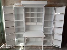 an empty room with several white shelving units