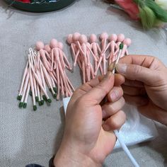 a person is making pink and green candles